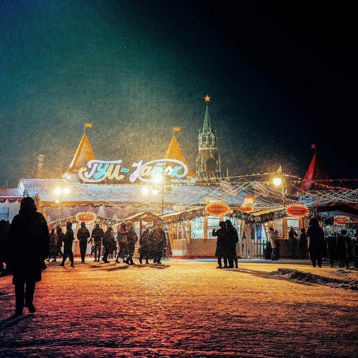 Люди около катка снежным вечером
