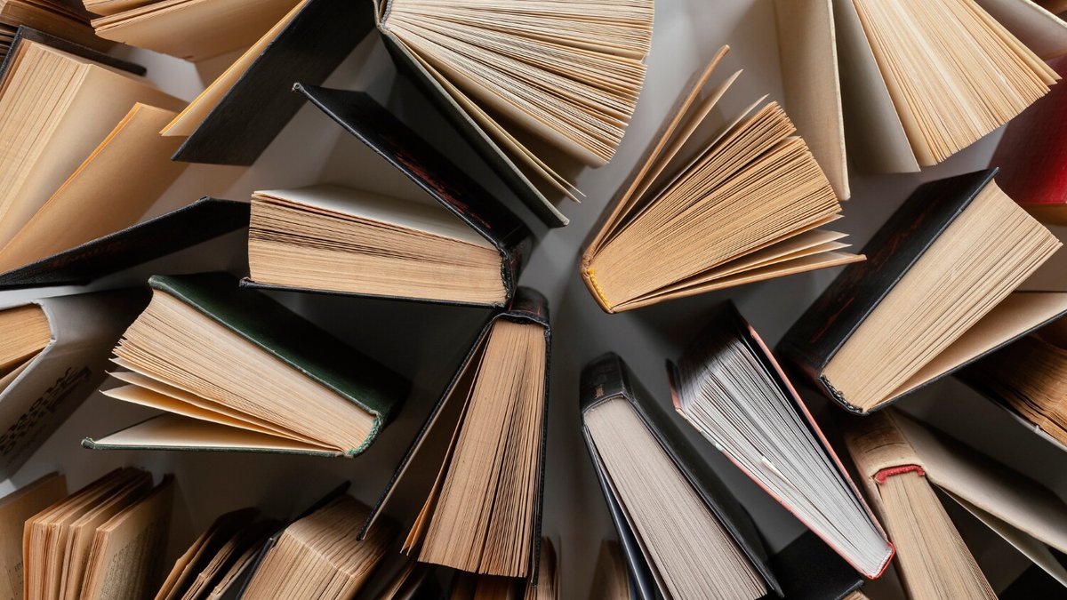 Вид на хаотично стоящие на столе книги сверху