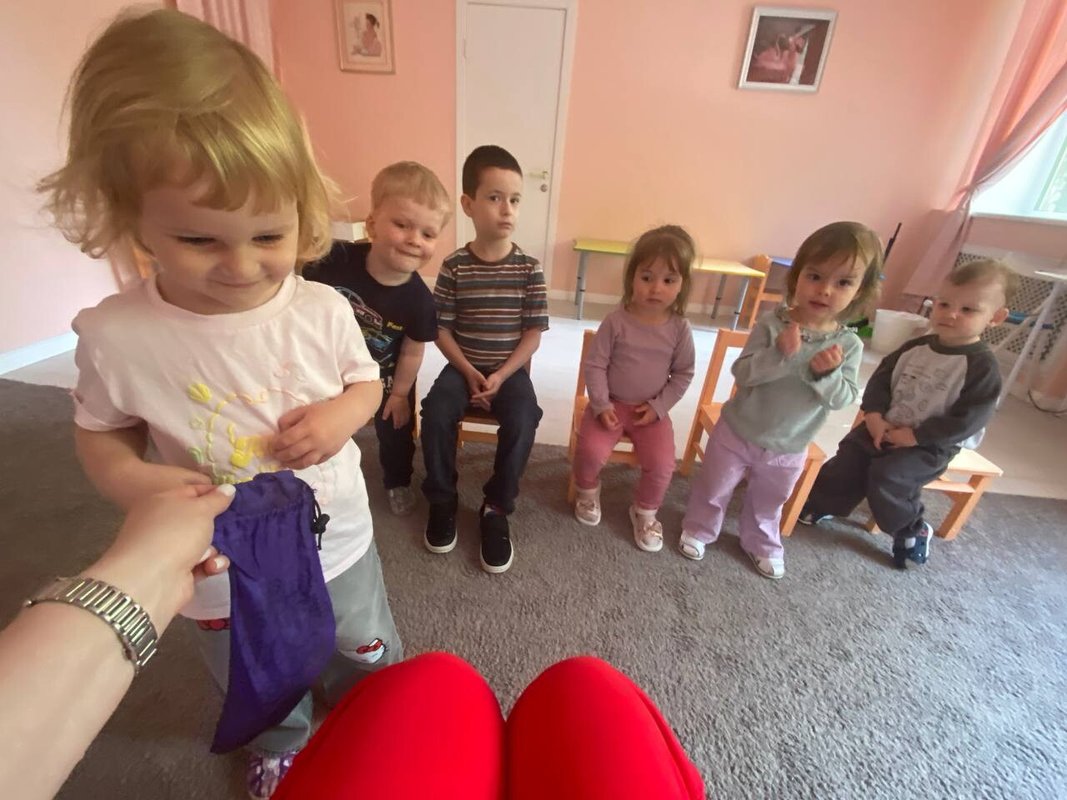 Воспитатель играет с группой детей в игровой комнате Бемби Клуба