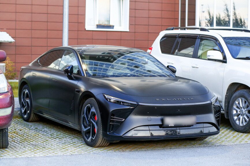 Автомобиль Exeed Exlantix ES черного цвета припаркован у здания