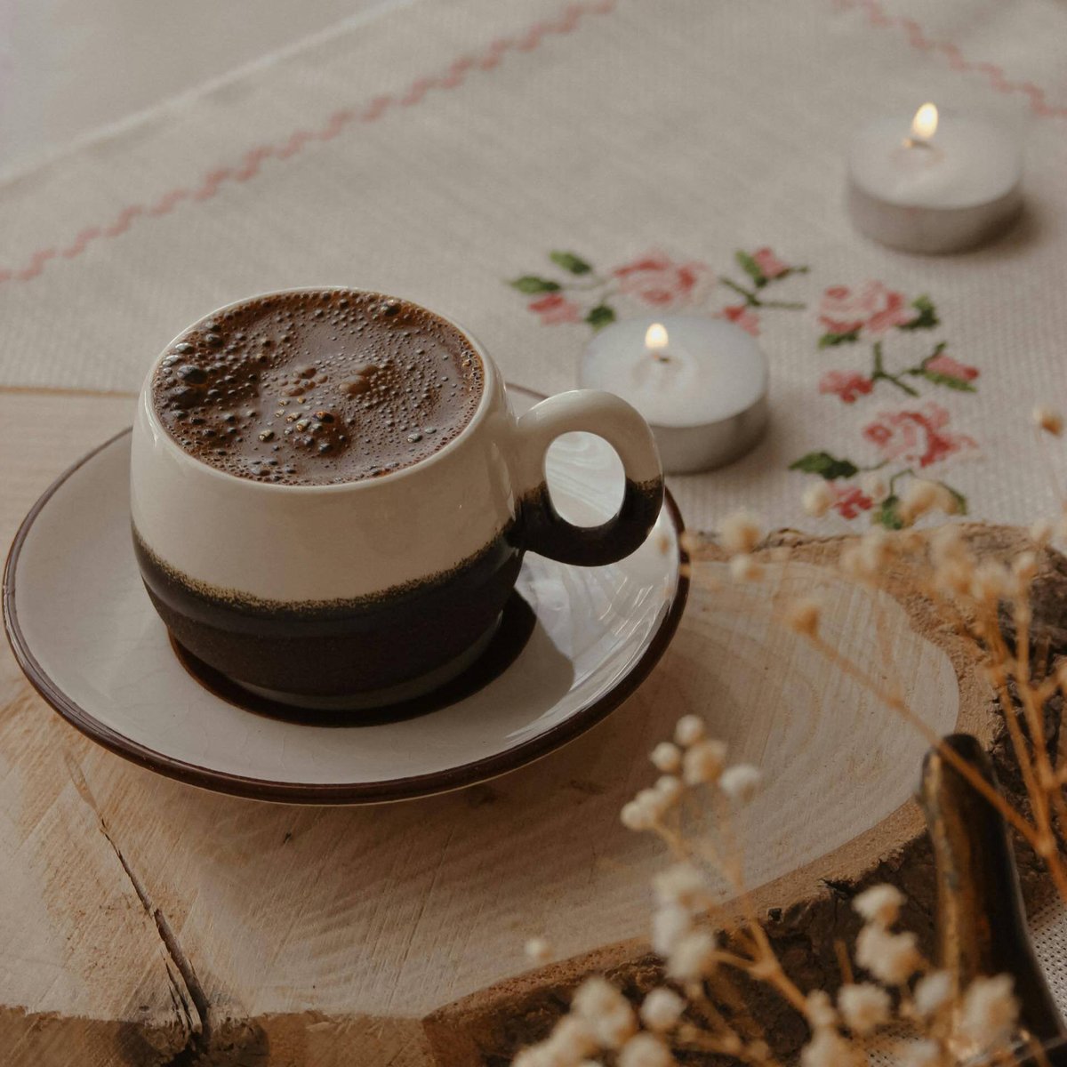 Кружка с напитком, рядом стоят свечи