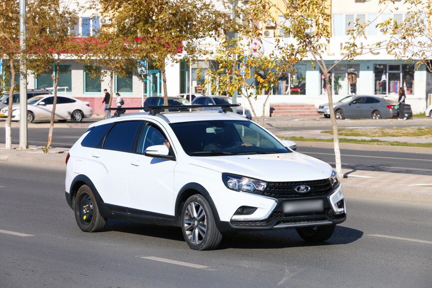 Автомобиль Лада Веста SW Cross белого цвета на городских улицах
